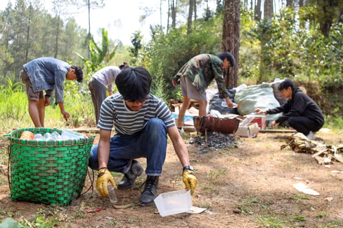 Preview: Group of young friends collecting plastic bottles to trash bags