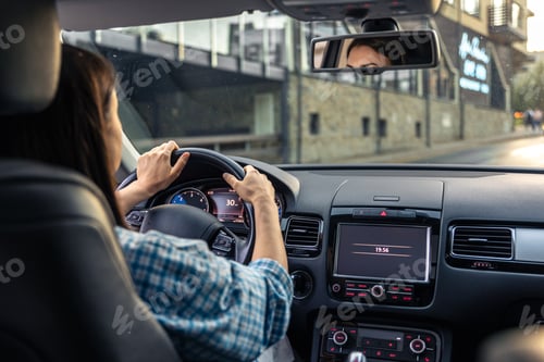 Preview: Woman driving a car, hands on the wheel close-up, view from the back to the road.