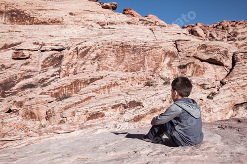 Preview: Child sitting and looking at mountains, enjoying beautiful view of nature