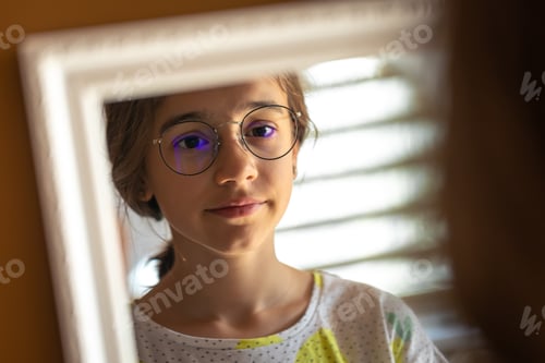 Preview: A teenage girl looks at herself in the mirror in the morning.