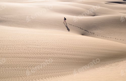 Preview: Minimalistic photo of a person walking in a big desert