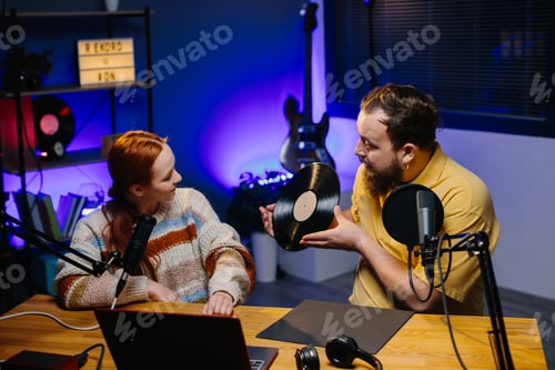 Preview: A male blogger with a vinyl record in his hands is having a live conversation with a woman.