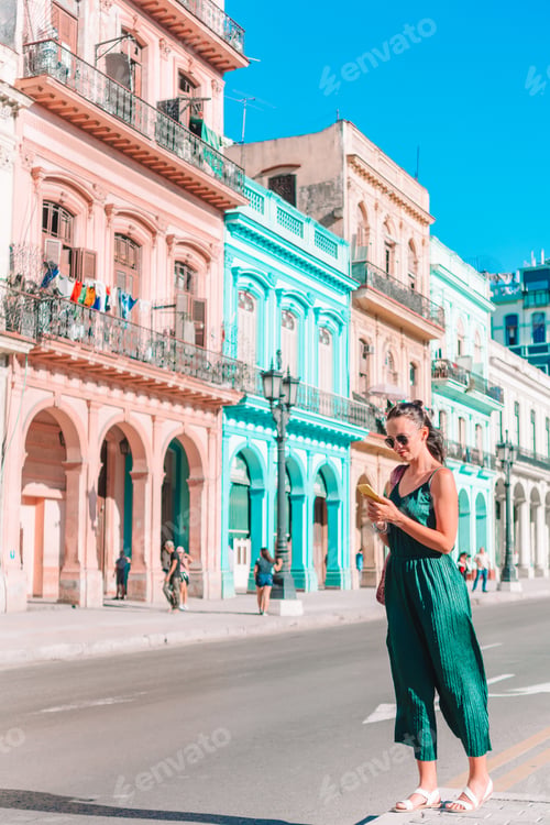 Preview: Tourist girl in popular area in Havana, Cuba. Back view of young woman traveler smiling