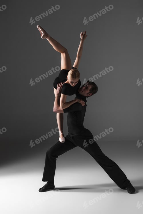 Preview: two young modern ballet dancers on gray studio background