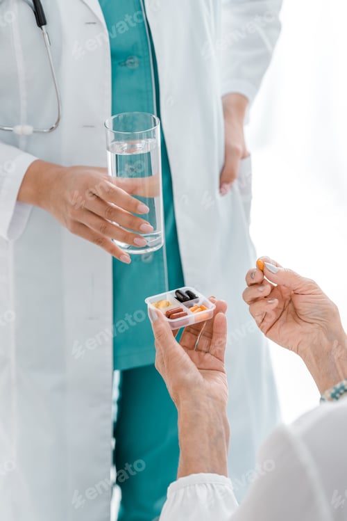 Visualização: Imagem de perto de uma jovem médica dando pílulas e um copo de água para uma mulher idosa