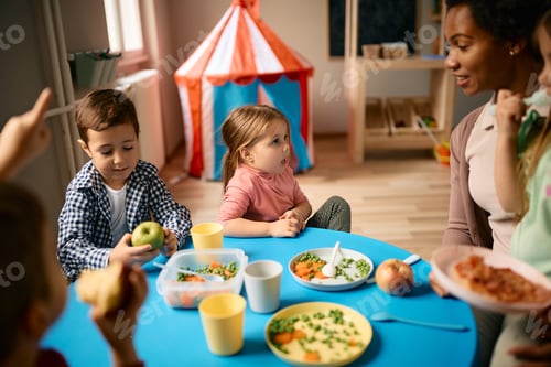 Preview: Group of small kids having lunch at preschool.