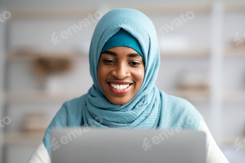 Preview: Closeup Shot Of Black Muslim Lady In Blue Hijab Using Laptop