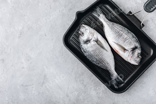 Preview: Fresh raw dorado fish with spices. Ingredients for cooking in cast iron grill pan.