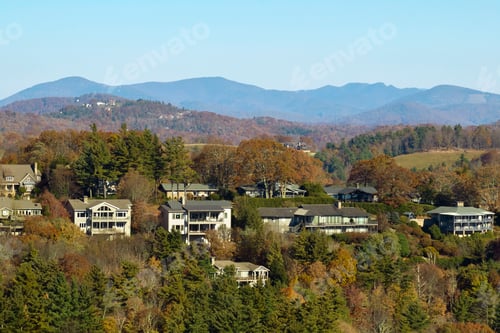 Preview: Aerial view of big family houses on mountain top between yellow trees in North Carolina
