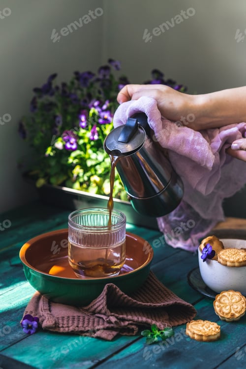 Preview: coffee in transparent cup with homemade cookies - selfish breakfast. Green wooden table with pansies