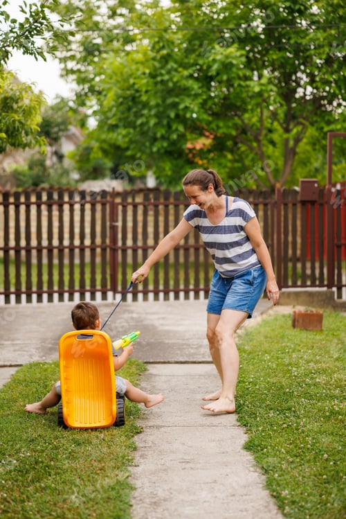 Preview: Mother having fun pushing child in toy truck