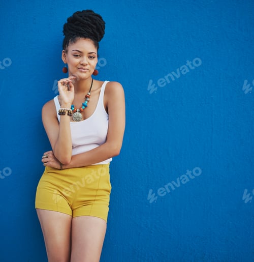 Preview: Portrait of an attractive and trendy young woman posing against a blue background