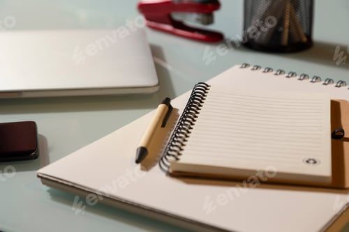 Preview: Notepad with laptop and mobile phone on glass table. Selective focus. Telework concept