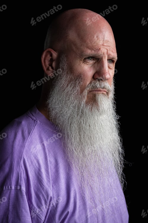 Preview: Portrait of man with long gray beard wearing purple t-shirt close-up shot