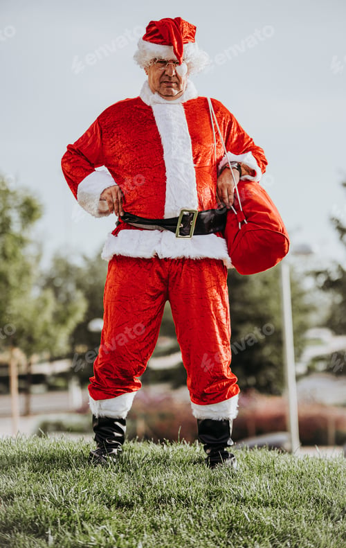 Preview: Vertical photo of papa noel without beard with arms resting on the body and yawning. Christmas time