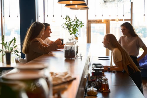 Preview: Woman is laughing next to three friends at the bar