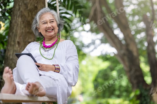 Preview: Elderly woman enjoying a peaceful moment on a swing