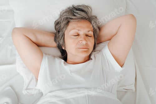Preview: Top view contented senior woman enjoying sleep.