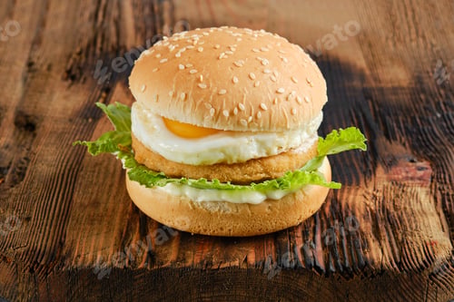 Preview: Chicken burger with fried egg and iceberg lettuce on wooden board