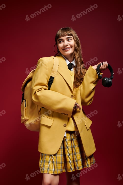 Preview: Young female student in oversized blazer posing with a cheerful smile against a vibrant backdrop