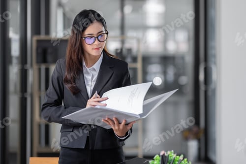 Preview: Portrait of cheerful young Asian business woman holding document folder and gets brilliant idea in
