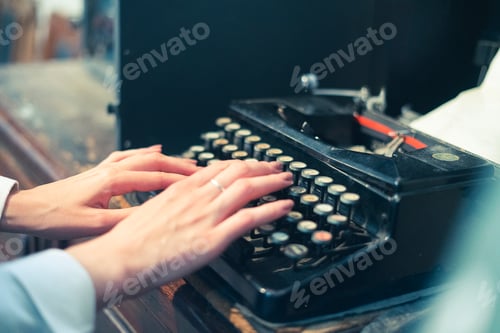 Preview: a female person typing text using and old typewriter machine