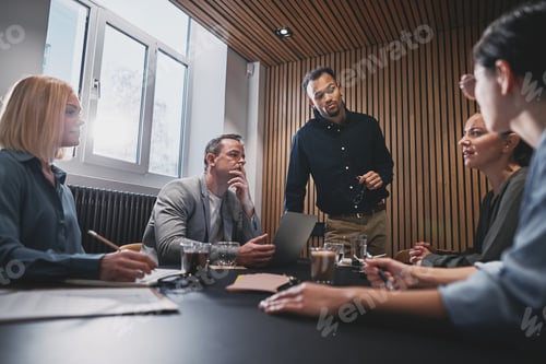 Preview: Diverse businesspeople discussing work during a boardroom meeting