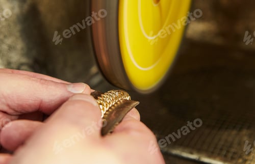 Preview: Jewelry production. Jeweler polishes a gold bracelet