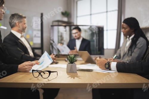 Preview: Focus on eyeglasses on the table. Diverse multiracial businesspeople having video conference.