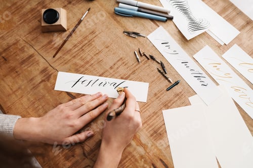 Preview: Calligrapher girl writing while working at table indoors