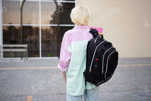 Preview: Photography from back of student girl with folders and big backpack.