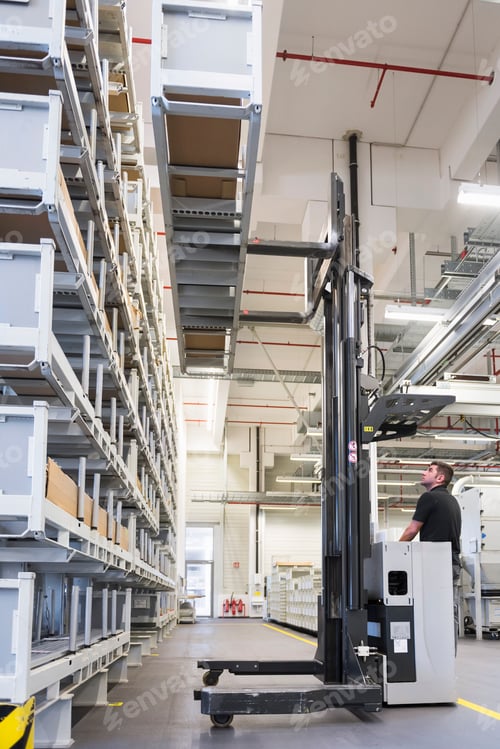 Preview: Worker operating forklift in factory warehouse
