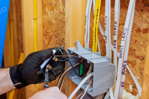 Preview: Electrician performing wiring installation in residential building construction switches visible