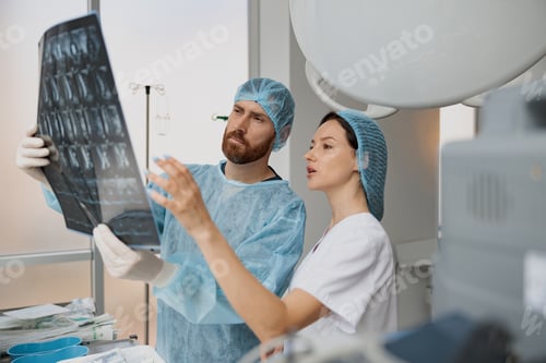 Preview: Two doctors in uniform look and discuss an X-ray or MRI scan of the