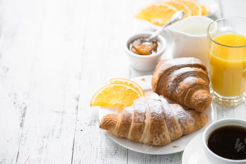 Preview: Fresh Croissants with Orange Juice on White Table