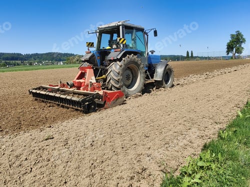 Preview: Big tractor standing in the middle of a farmland
