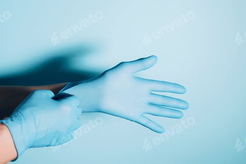 Preview: Hands Putting on a Blue Medical Glove