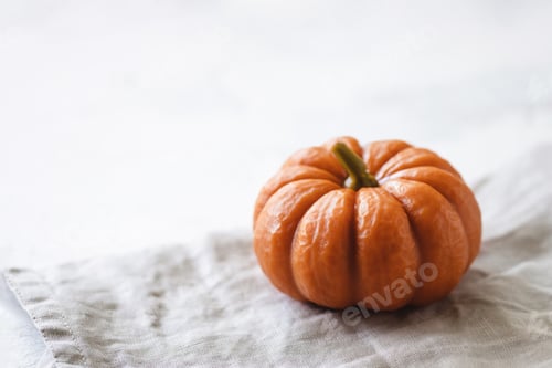 Preview: Pumpkin on cloth on table.