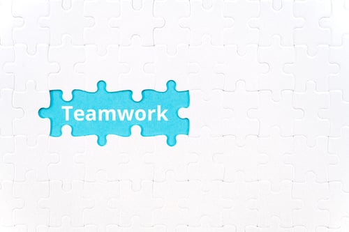 Preview: The word teamwork on a blue background in place of the taken out white puzzle
