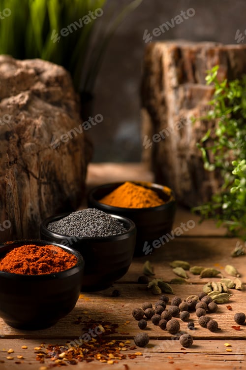 Preview: Three black small bowls with spices on a wooden table