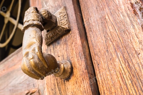 Preview: Old hand-shaped knob to knock on an old wooden door.