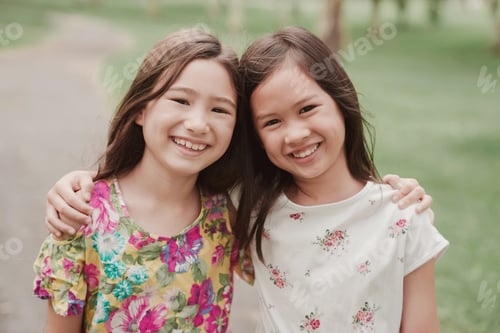 Preview: Happy mixed Asian young girls smiling in the park, friendship and diversity concept