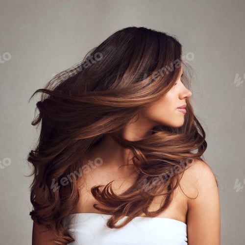 Preview: Studio shot of a young beautiful woman with long gorgeous hair posing against a grey background