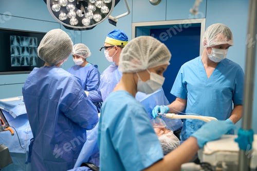 Preview: Team of surgeons performs an operation, a patient under anesthesia