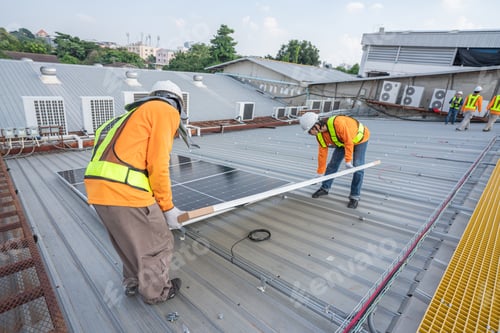 Preview: Team technicians carrying photovoltaic solar moduls on roof.