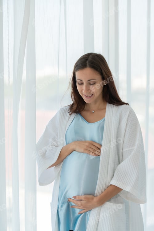 Preview: A pregnant woman in a bedroom with white curtains and early morning atmosphere