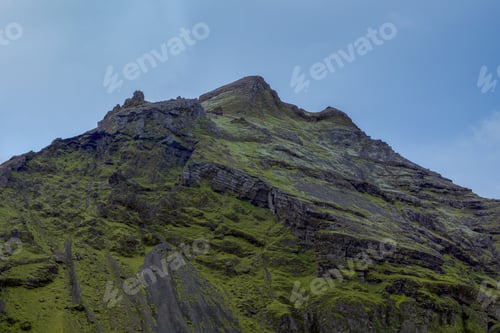 Preview: Tranquil scene of a green rocky mountain near Skogafoss, Iceland