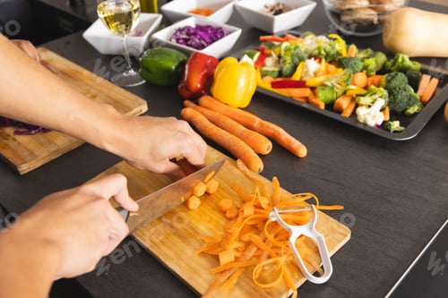 Preview: Hands of biracial man preparing meal, chopping carrots in kitchen, copy space