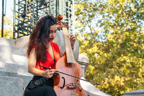 Preview: A young woman playing the cello outdoors