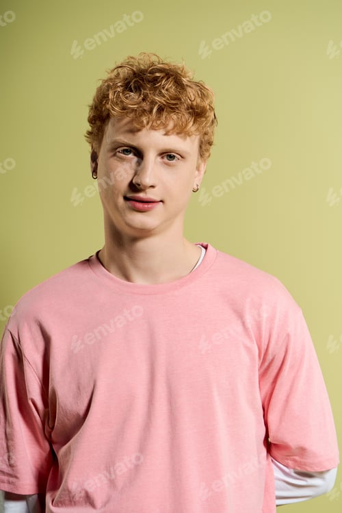 Preview: Stylish young man with curly hair in pastel tones against a warm backdrop
